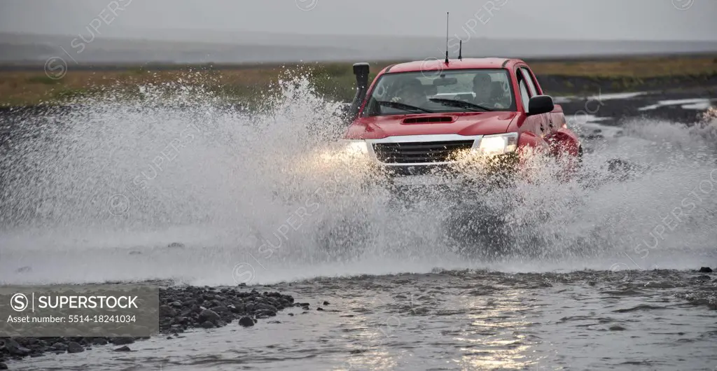 modified pick up truck driving through river on  Icelandic highlands