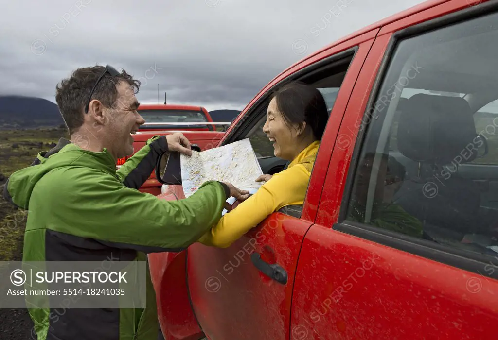 couple looking at map on road trip through the Icelandic highlands