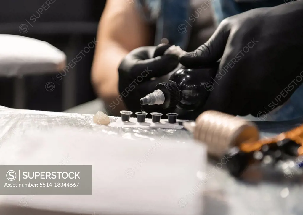 Cropped tattoo artist preparing ink