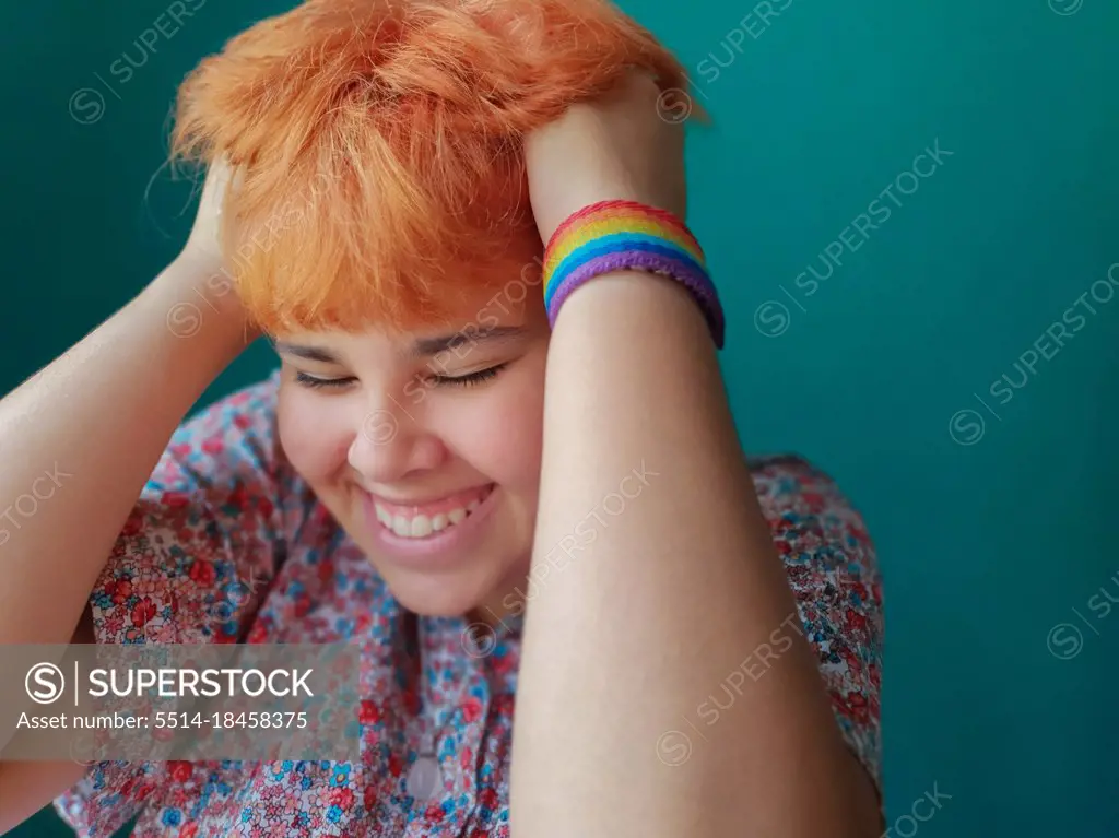 Red hair teenager girl with a LGTB bracelet smiling in a joyful moment