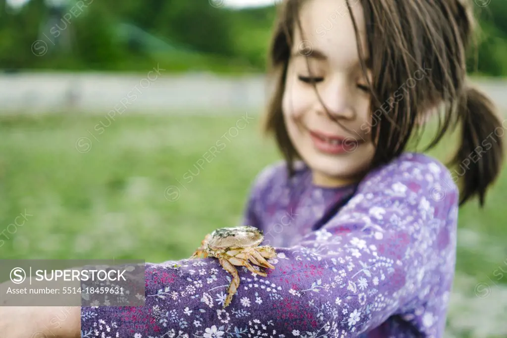 Closeup image of a shore crab on a child's arm