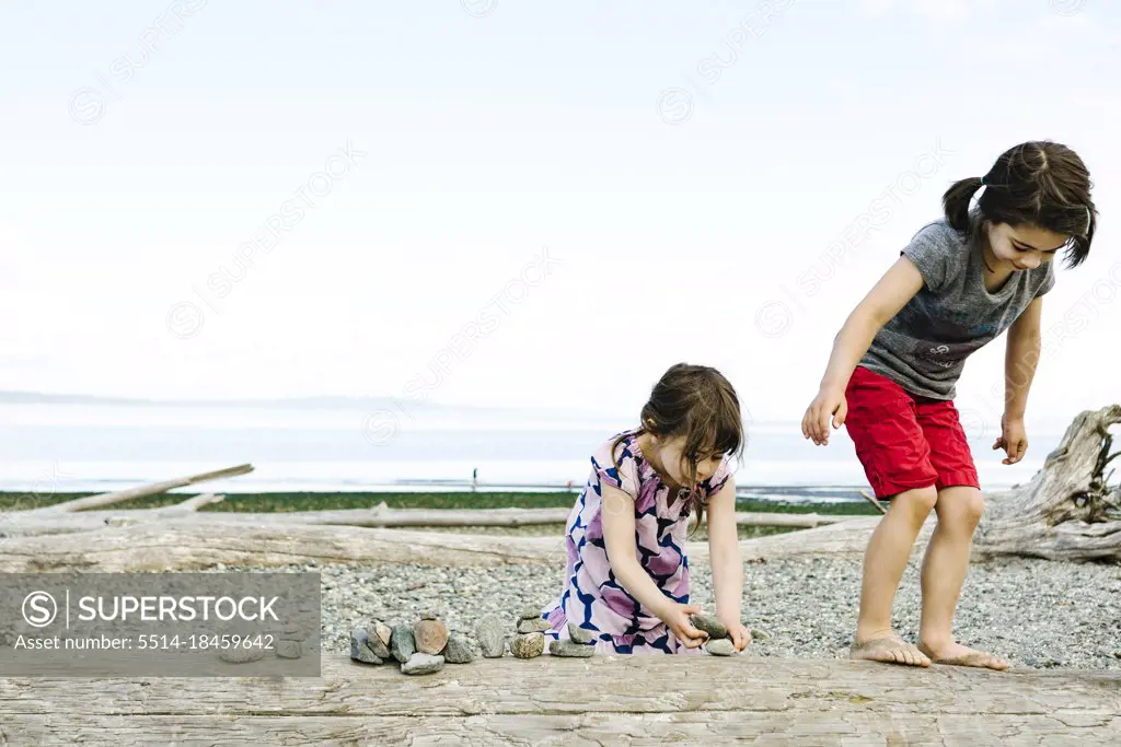 Two young girls playing together on the shores of Puget Sound