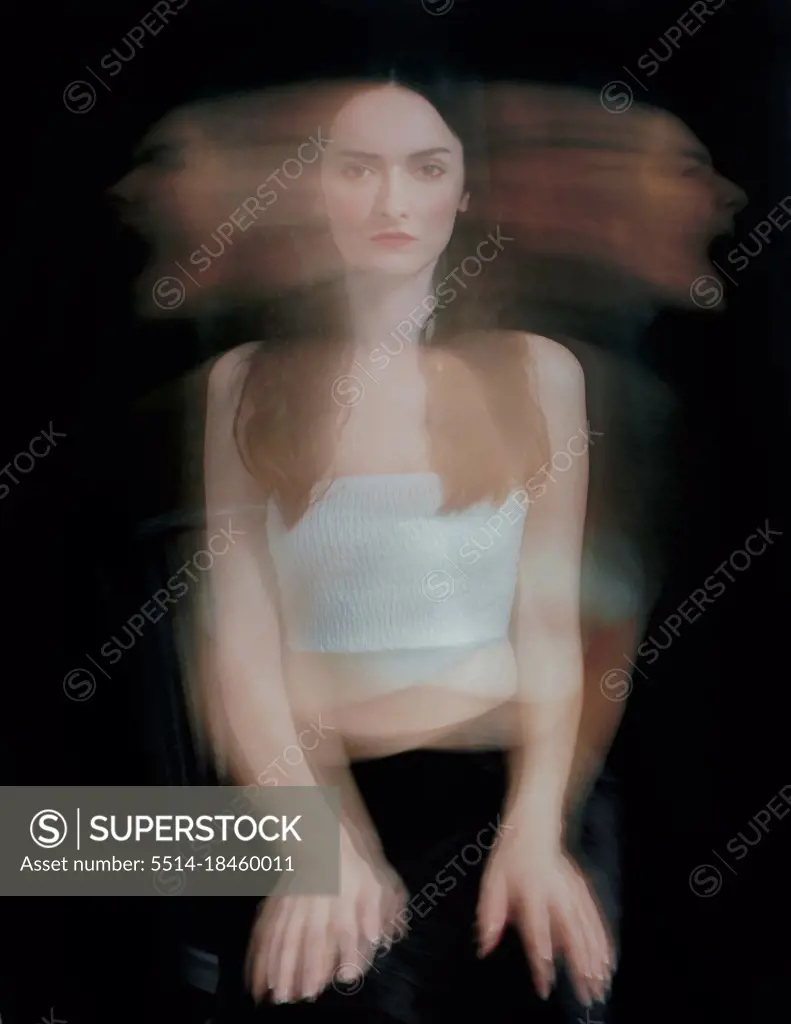 Dramatic psychological portrait of a woman on black, long exposure