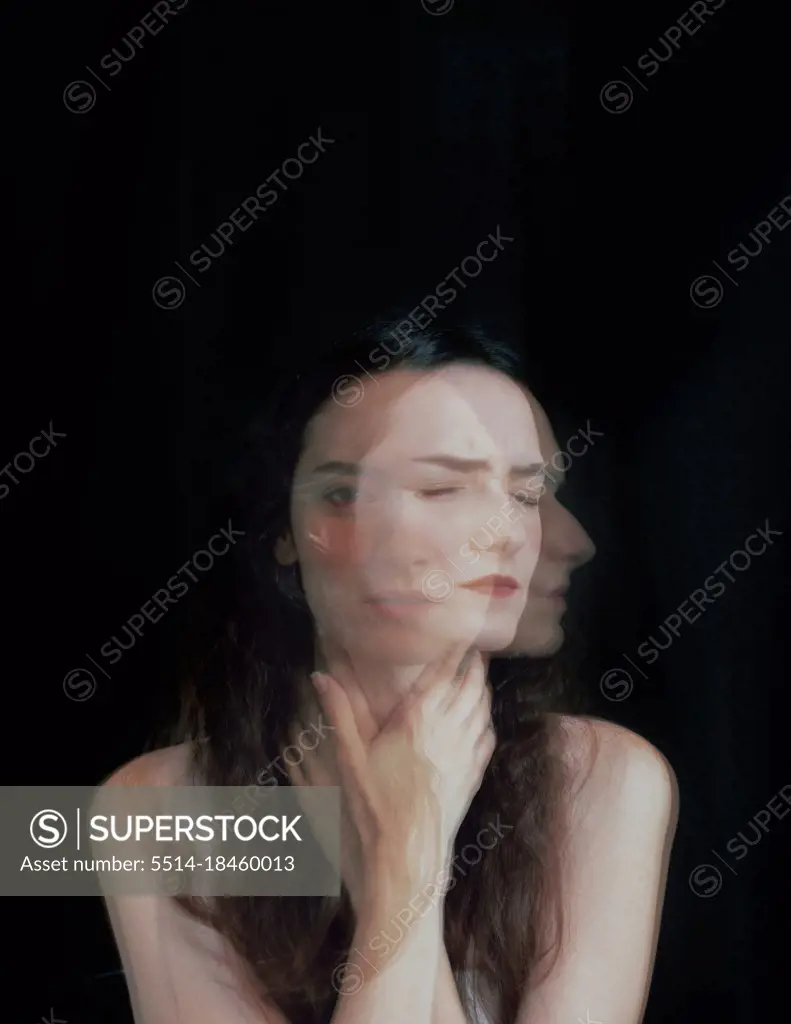 Dramatic psychological portrait of a woman on black, long exposure