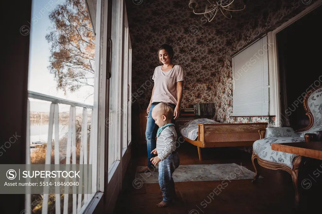 Mother and child in vintage bedroom with flower wallpaper
