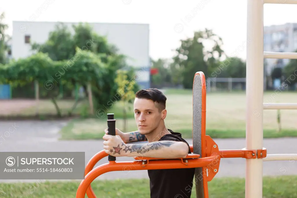 Man trains outside in the park on sports equipment