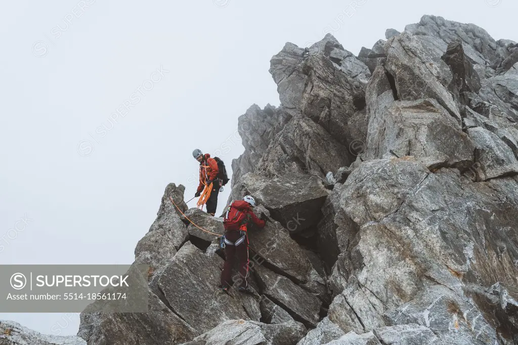 Two climbers descending exposed ridge on icy day