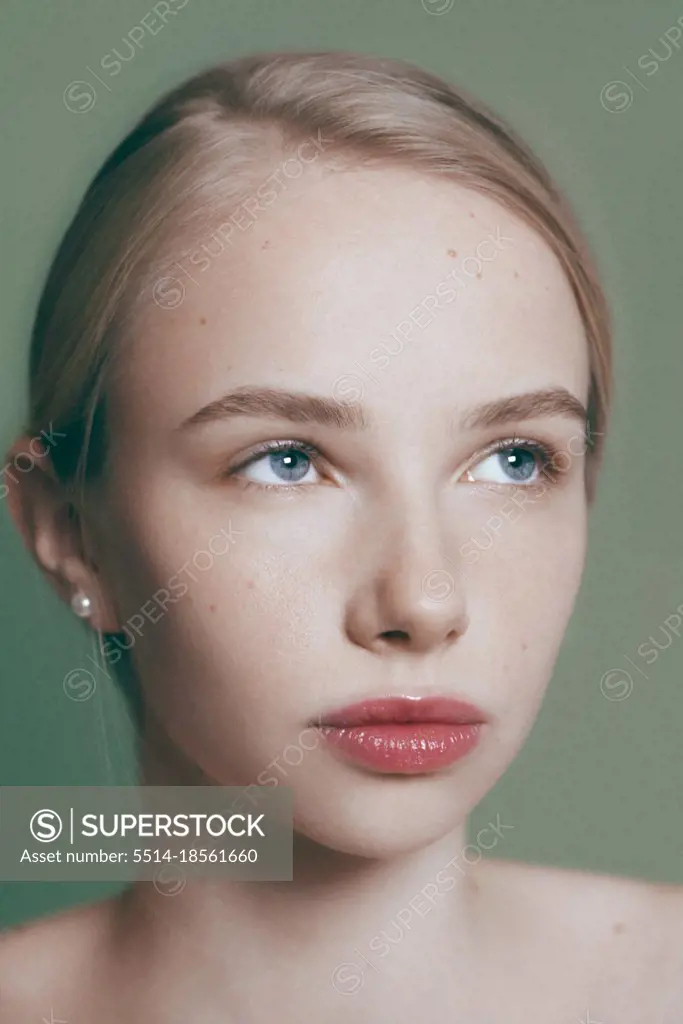 Young blonde model posing on green, sensual portrait