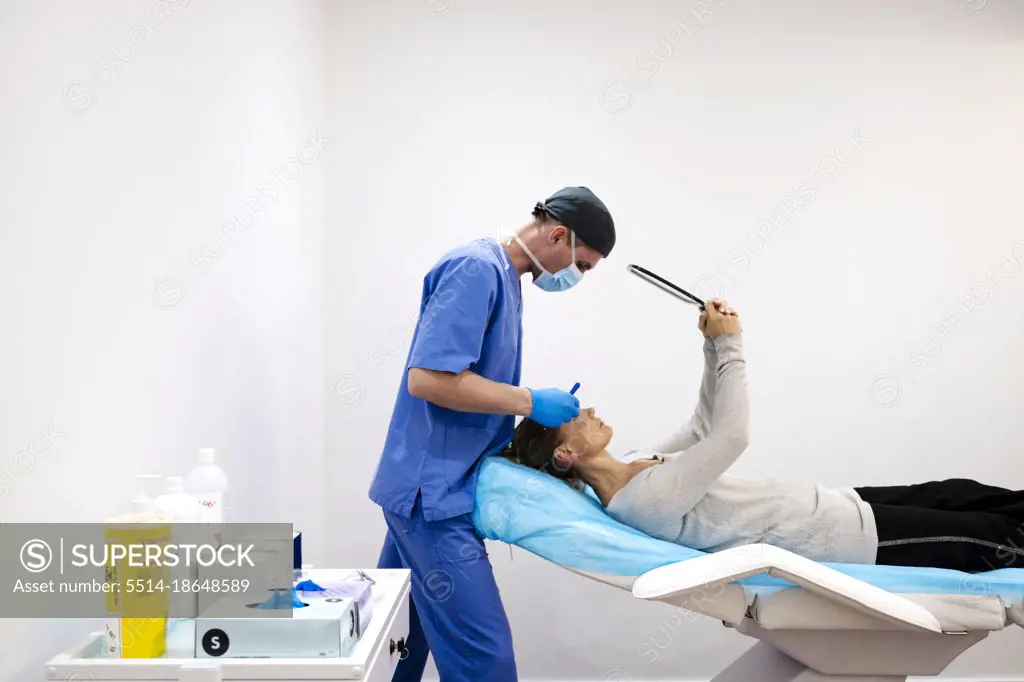 Female patient looking herself in the mirror, lying on the stretcher