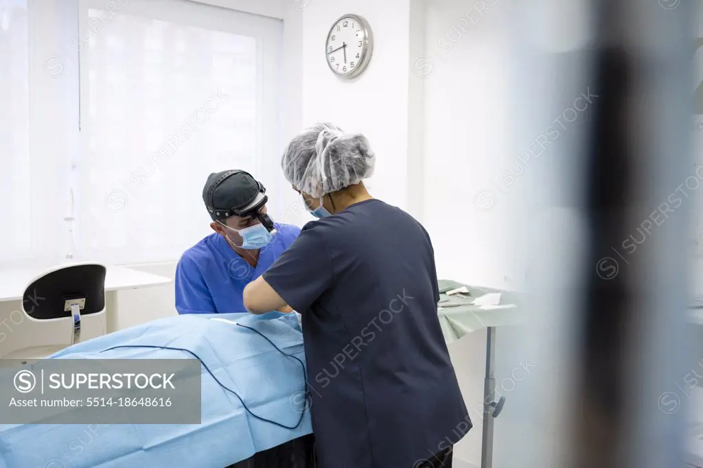 Surgeons performing eyelid surgery to anonymous patient