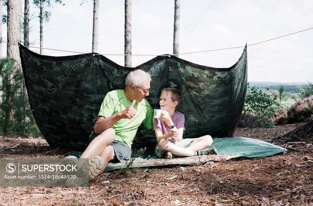 grandpa and grandchild building together in the forest on an adventure