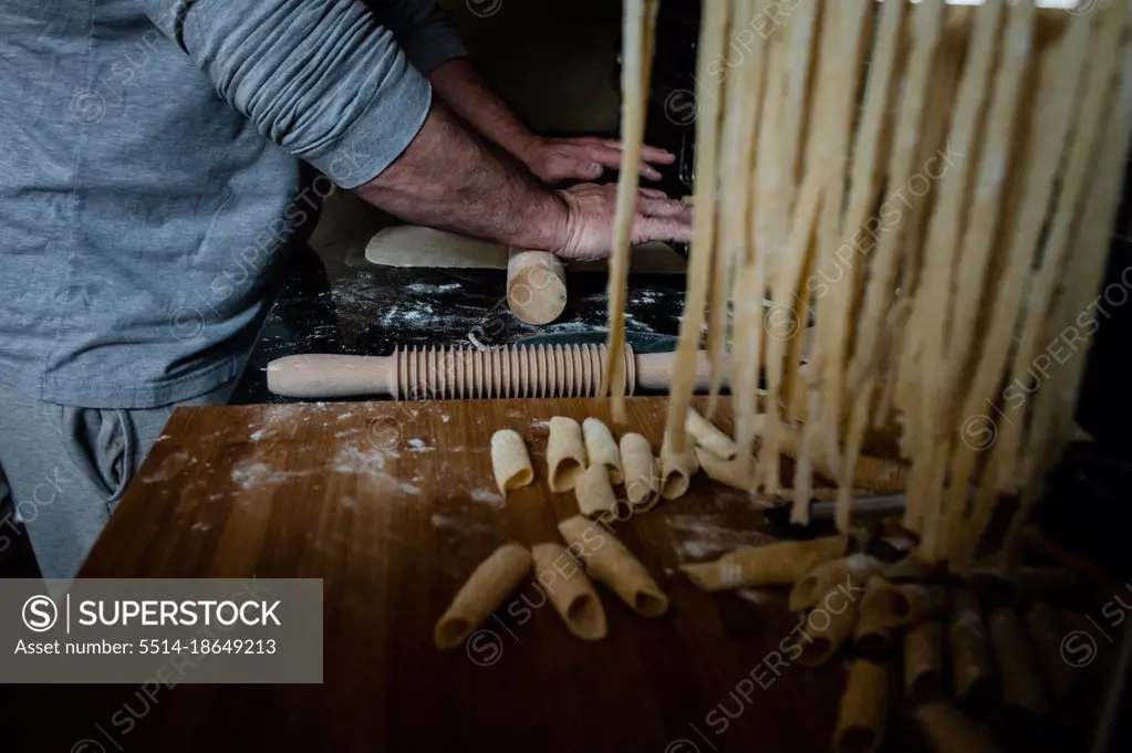 Man rolling out dough by hand for home made pasta