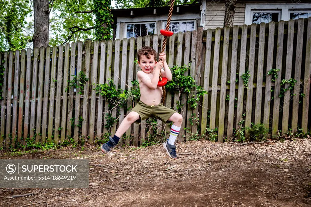 Boy on rope swing making a silly face