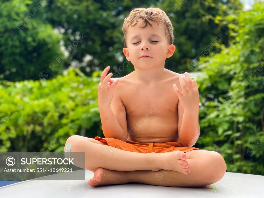 Young boy meditating outdoors on a sunny day