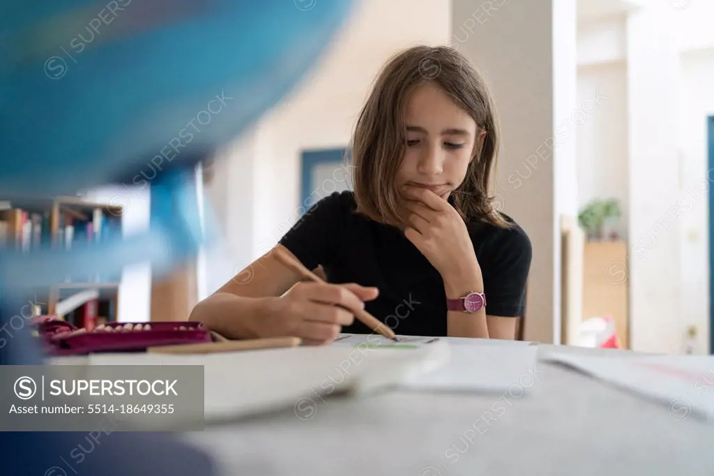 girl writing in exercise book at home