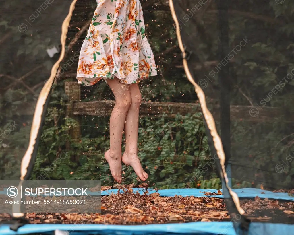 Jumping in the fall leaves on her trampoline