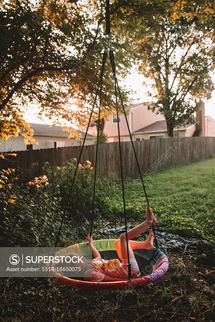 Swinging on her tree swing at sunset