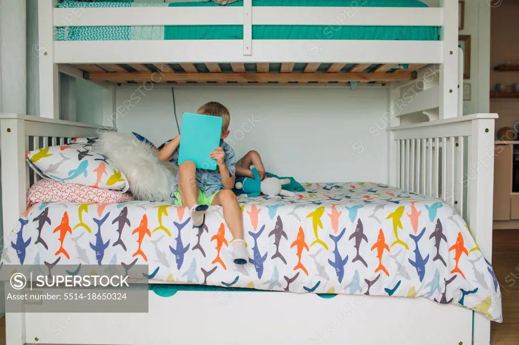 Young brothers relax on bunk beds in rental house on vacation