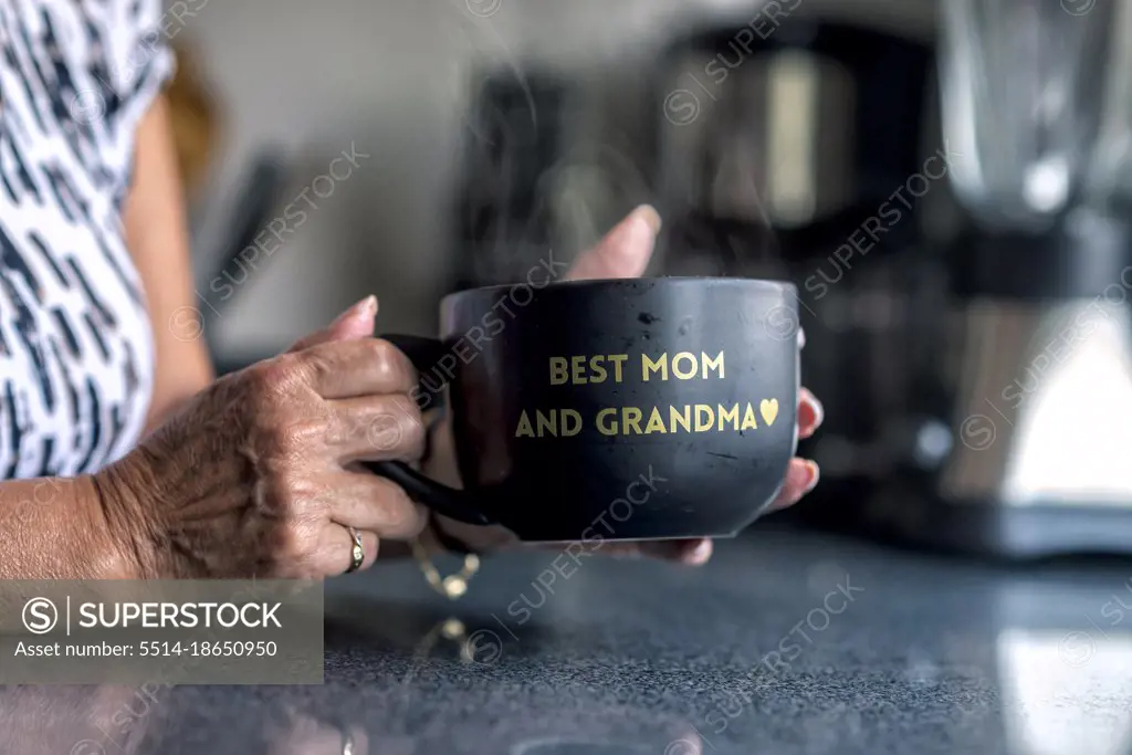 A latin grandma holding a black mug with a frase