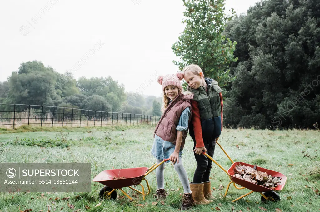 kids playing with wheelbarrows foraging in the forest in fall