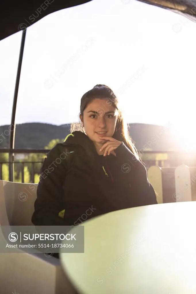 Girl sitting on a terrace of a bar while looking at the camera