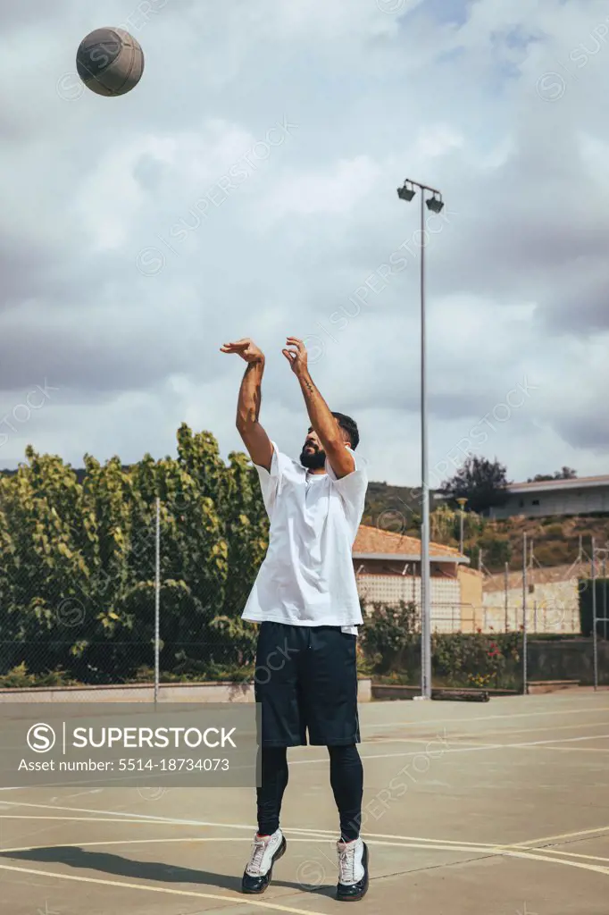 Young boy playing on a court while shooting basketball to basket
