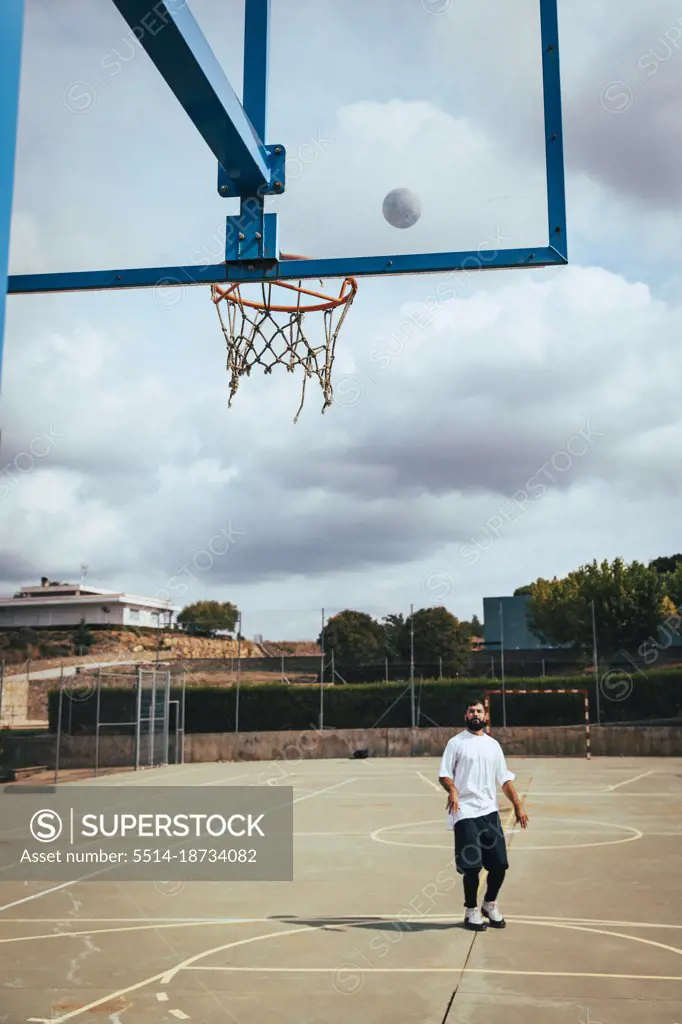 Young boy throwing a basketball to basket on a court