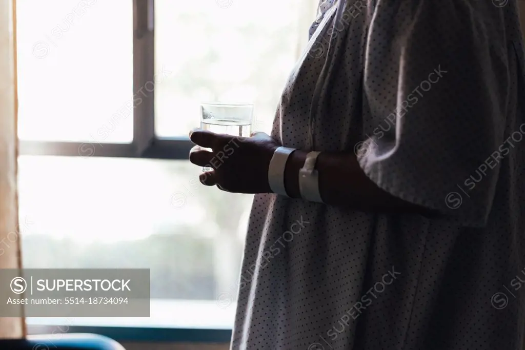 Close-up shot of a hospital patient holding a glass of water