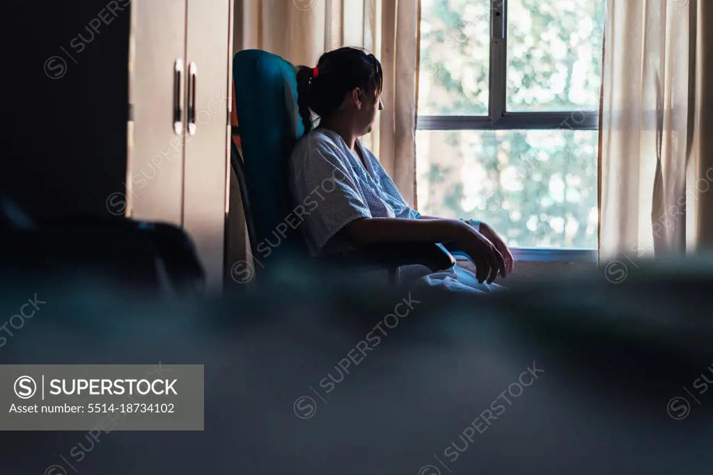 Young woman admitted in a hospital. Sitting on a chair.