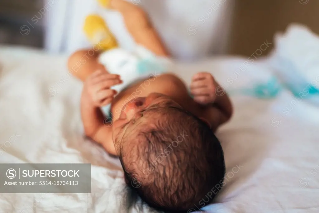 Newborn baby lying in a hospital bed.