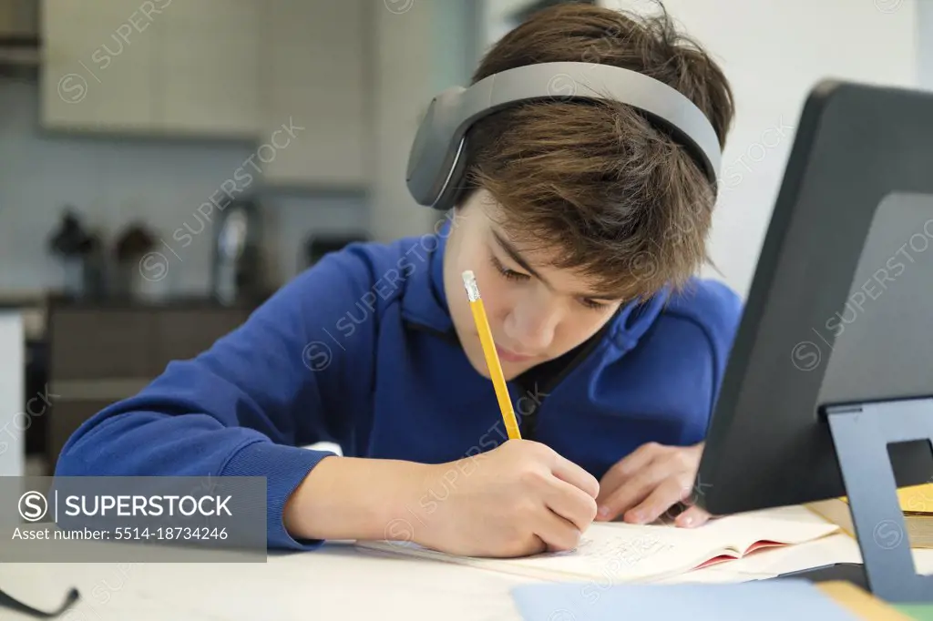 Student boy with tablet computer learning at home