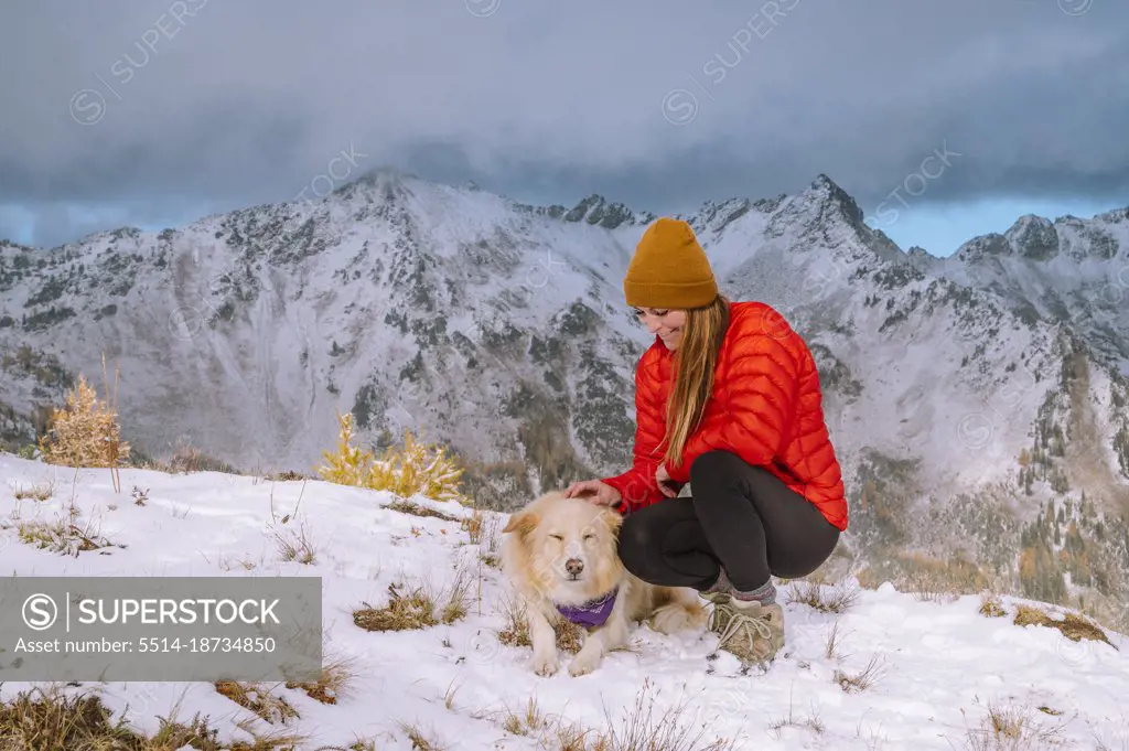 Petting a Cute Fluffy Dog On a Snowy Mountain Top