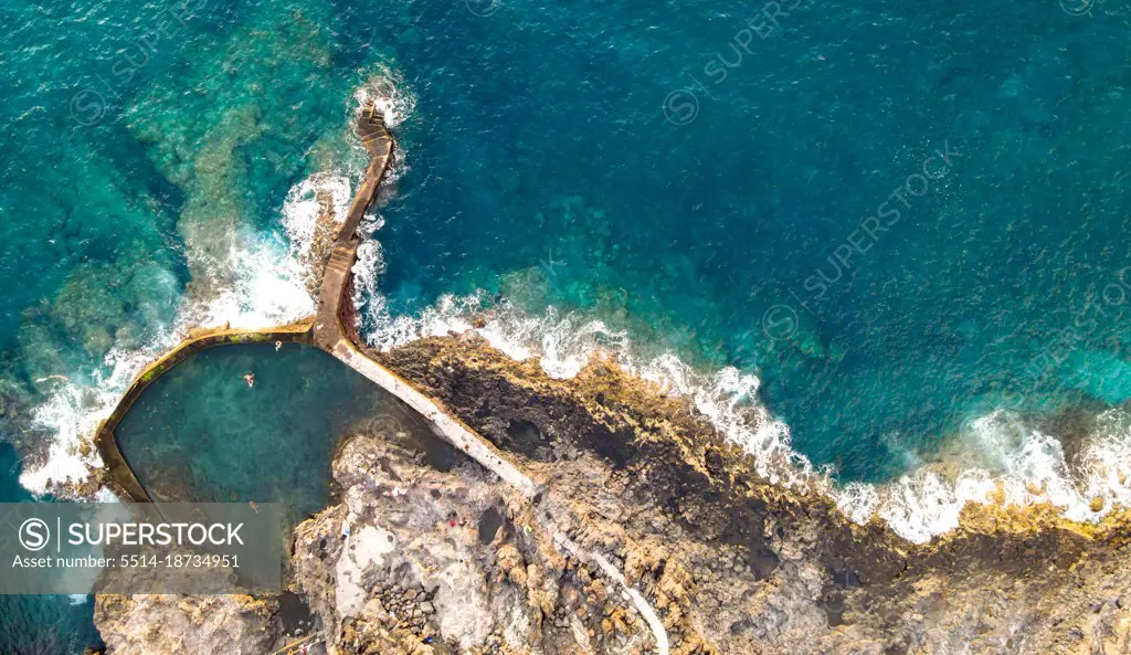aerial view of natural  pool near to the alantic ocean with 3 person