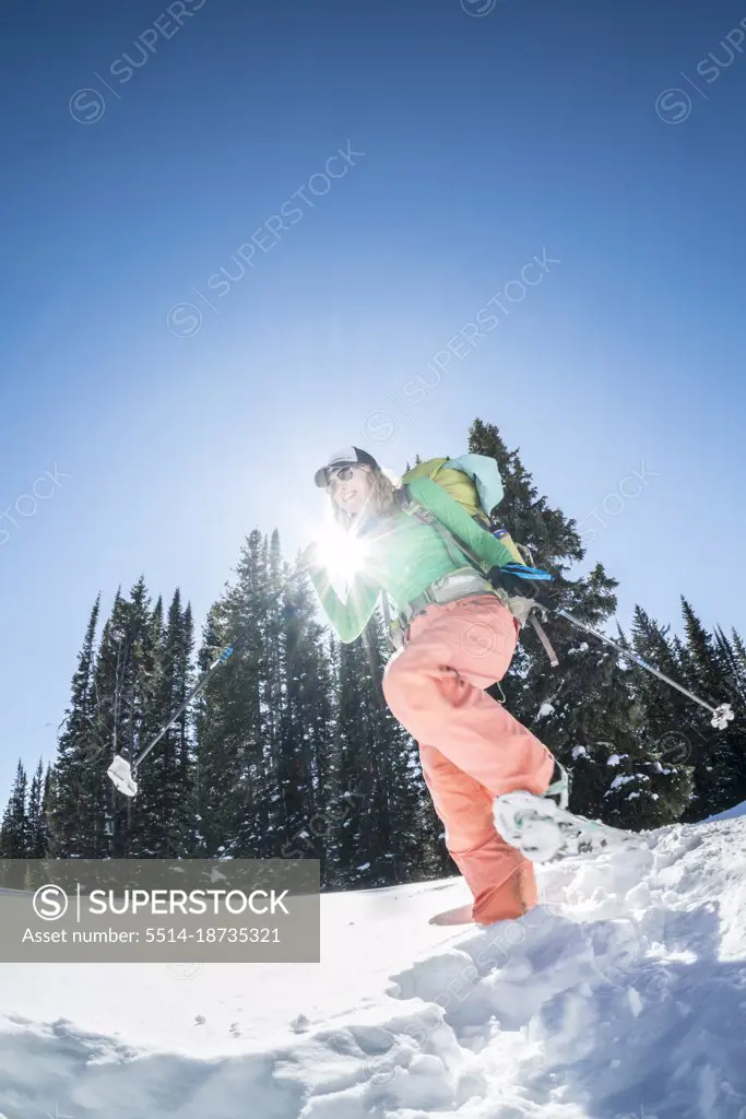 Woman on snowshoes with sun behind