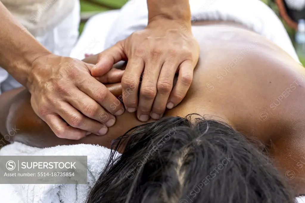 Man's hands massaging multiracial woman's neck