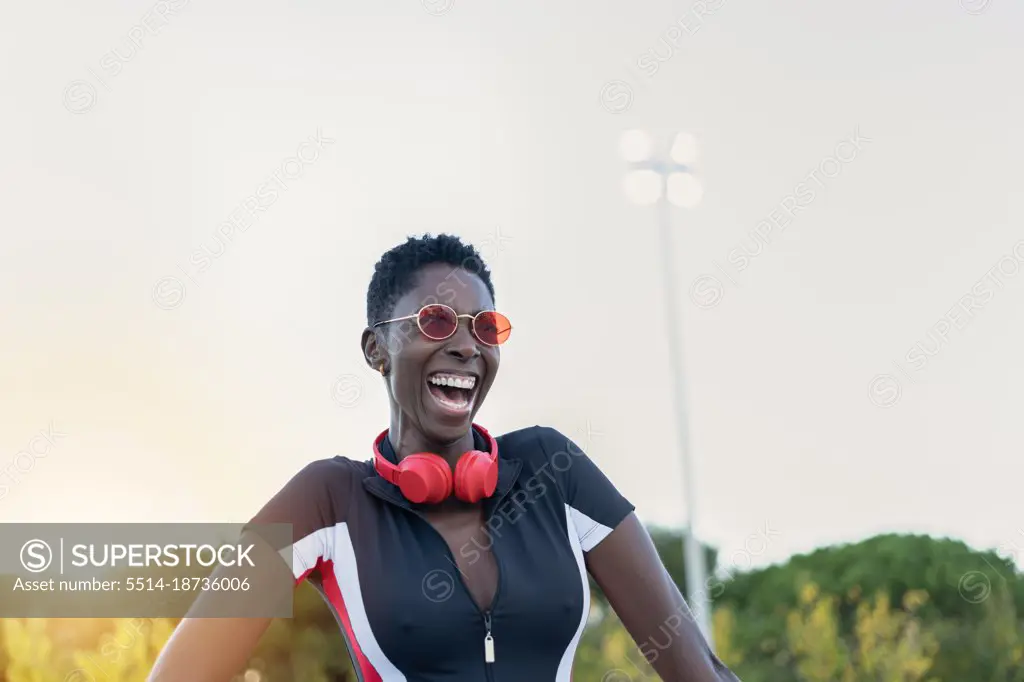 Portrait of cheerful afro american woman smiling in red sunglasses