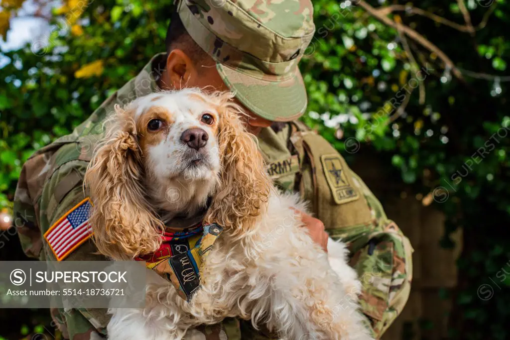 Army private in fatigues in the autumn with rescue dog