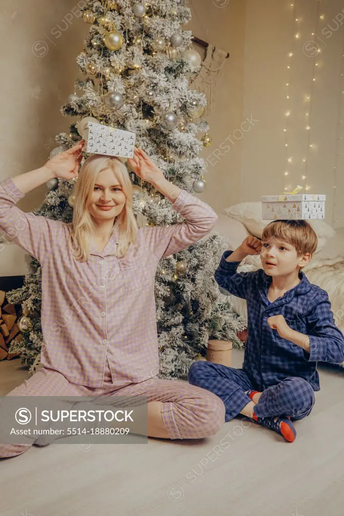 Mom and son with Santa's gifts under the Christmas tree.