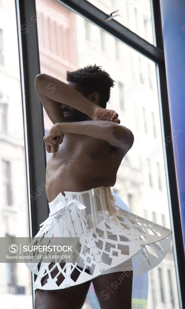 Male Dancer in White Tutu Covering His Face as Window Display