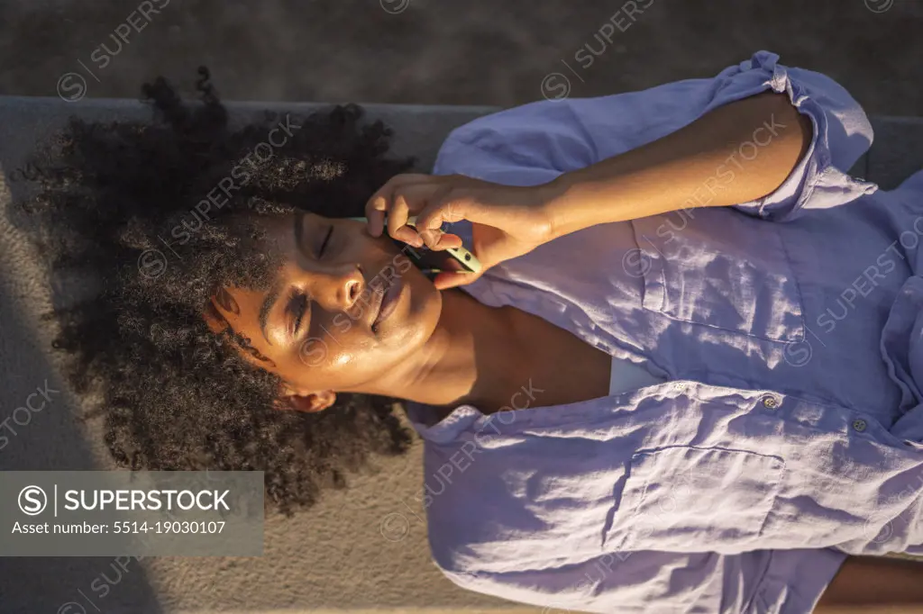 Beautiful young black woman happy while talking with her smartphone