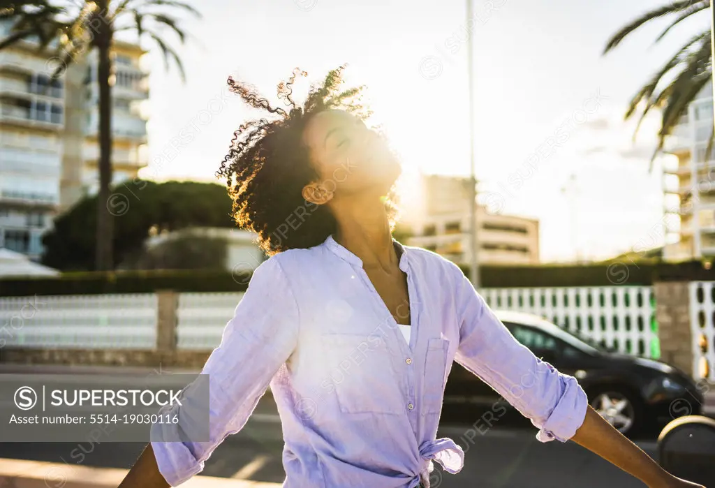 Smiling young black woman enjoying summer sunset