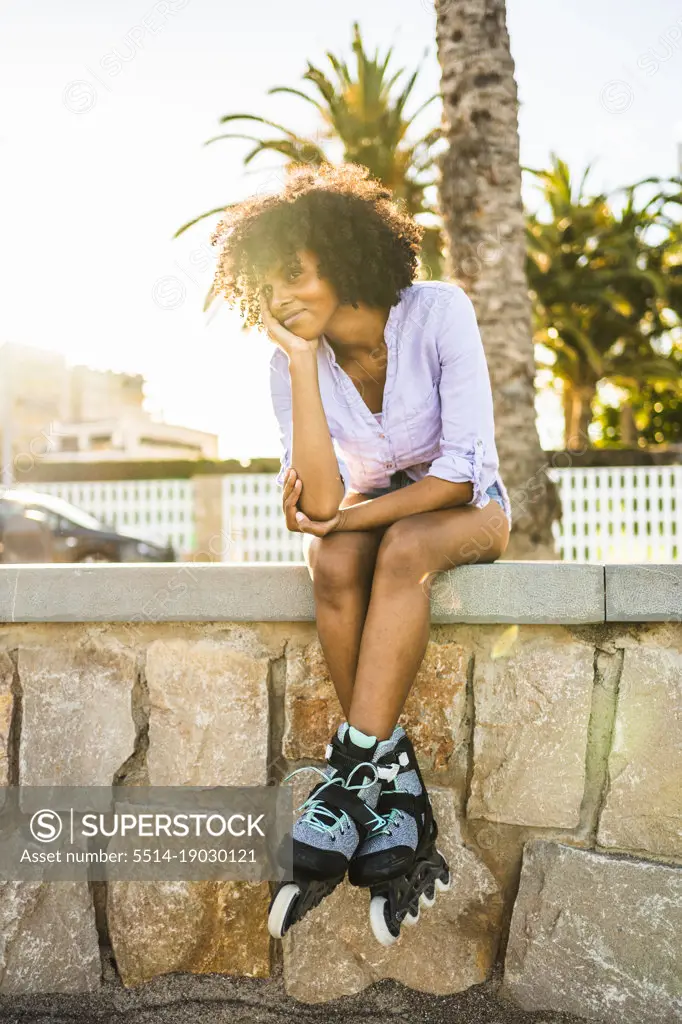Beautiful young black woman resting relaxed with her roller skates