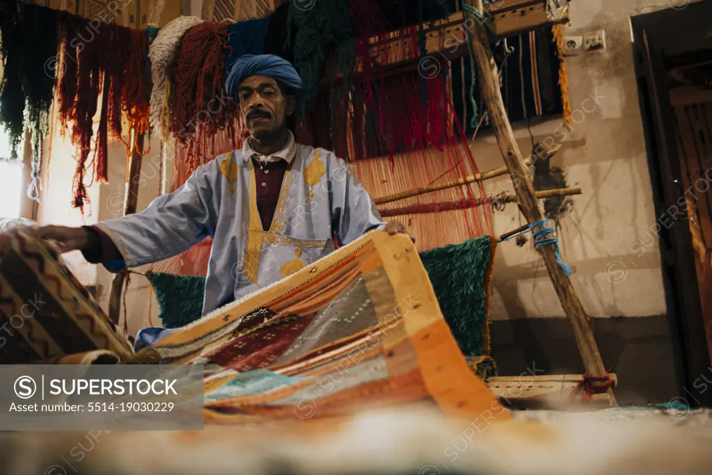 Front view of an Arab vendor of handmade carpets.