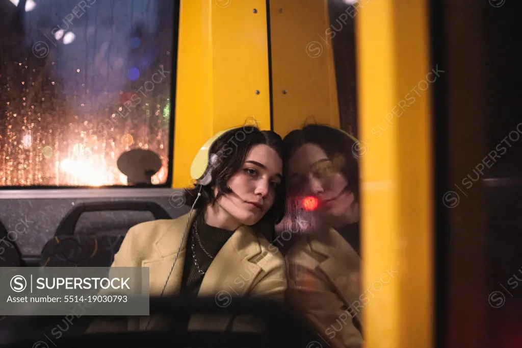 Young woman looking through window traveling in trolley bus