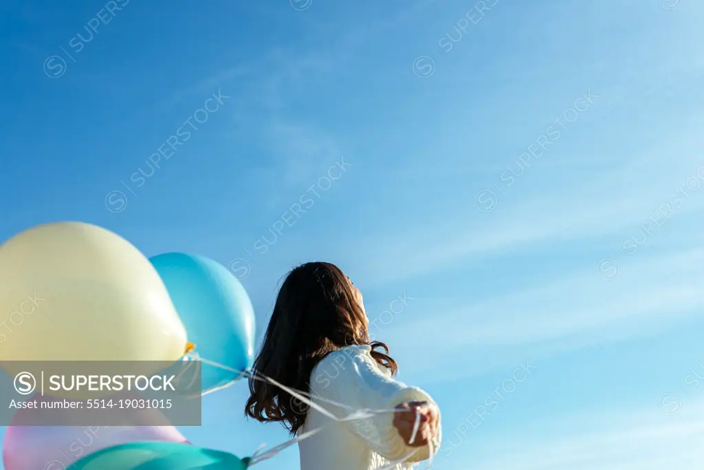 Anonymous Young Woman Playing With Colorful Balloons