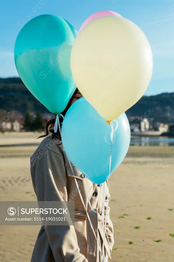 Young Woman Covering Her Face With Balloons