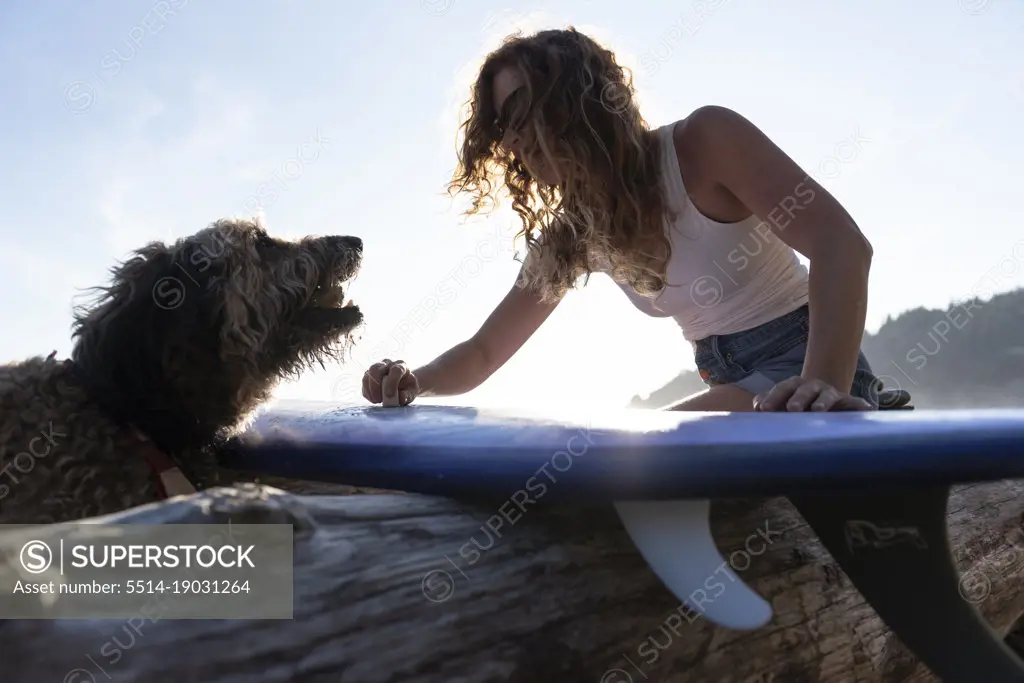 Surfer playing with her dog on the Oregon coast