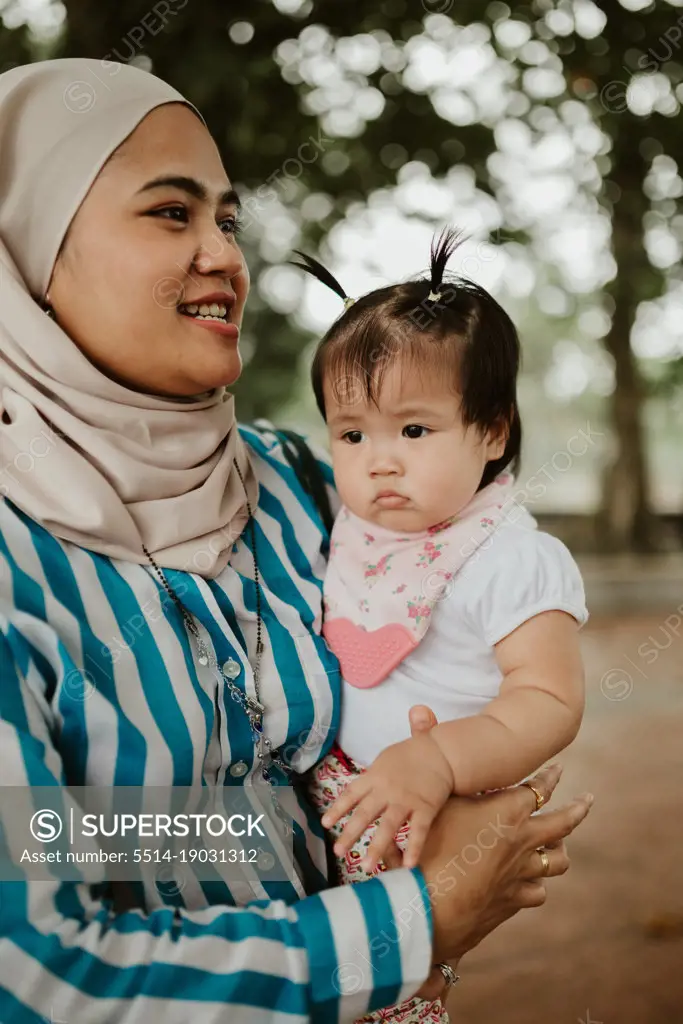 Mother holding baby girl in the park