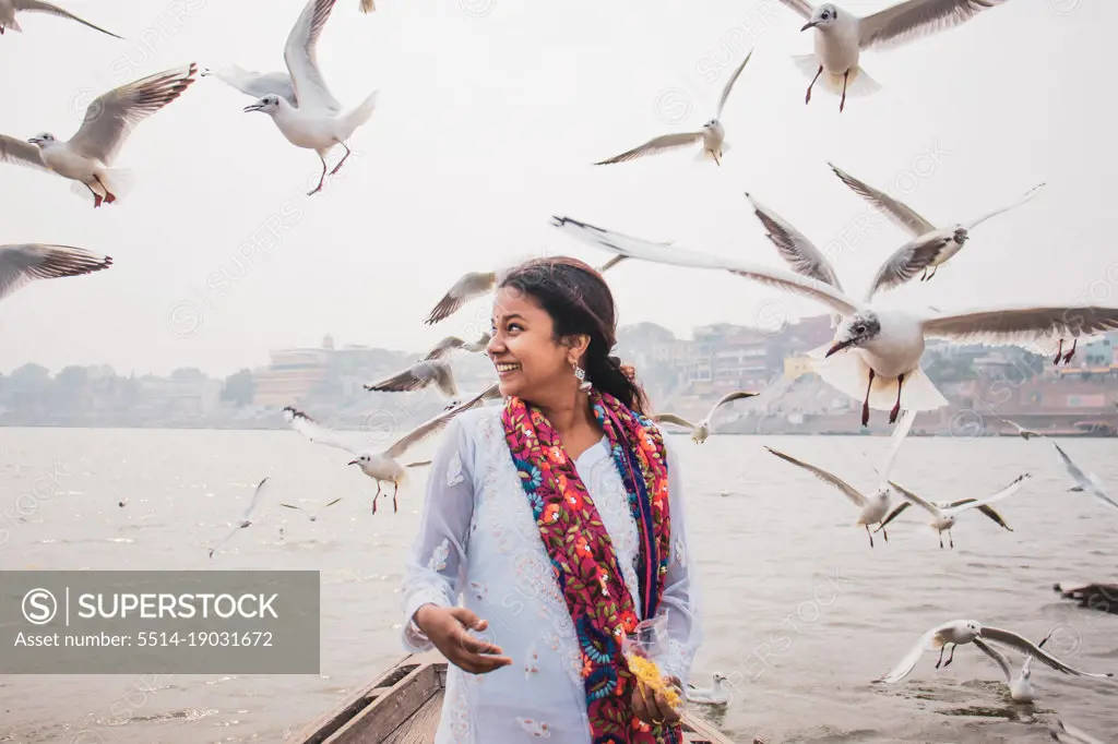 Girl posing in Varanasi surrounding by birds