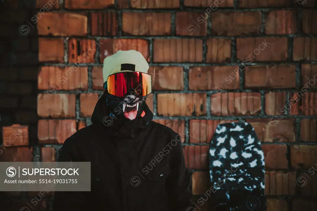 Young athlete snowboarder posing with snow jacket goggles and buff